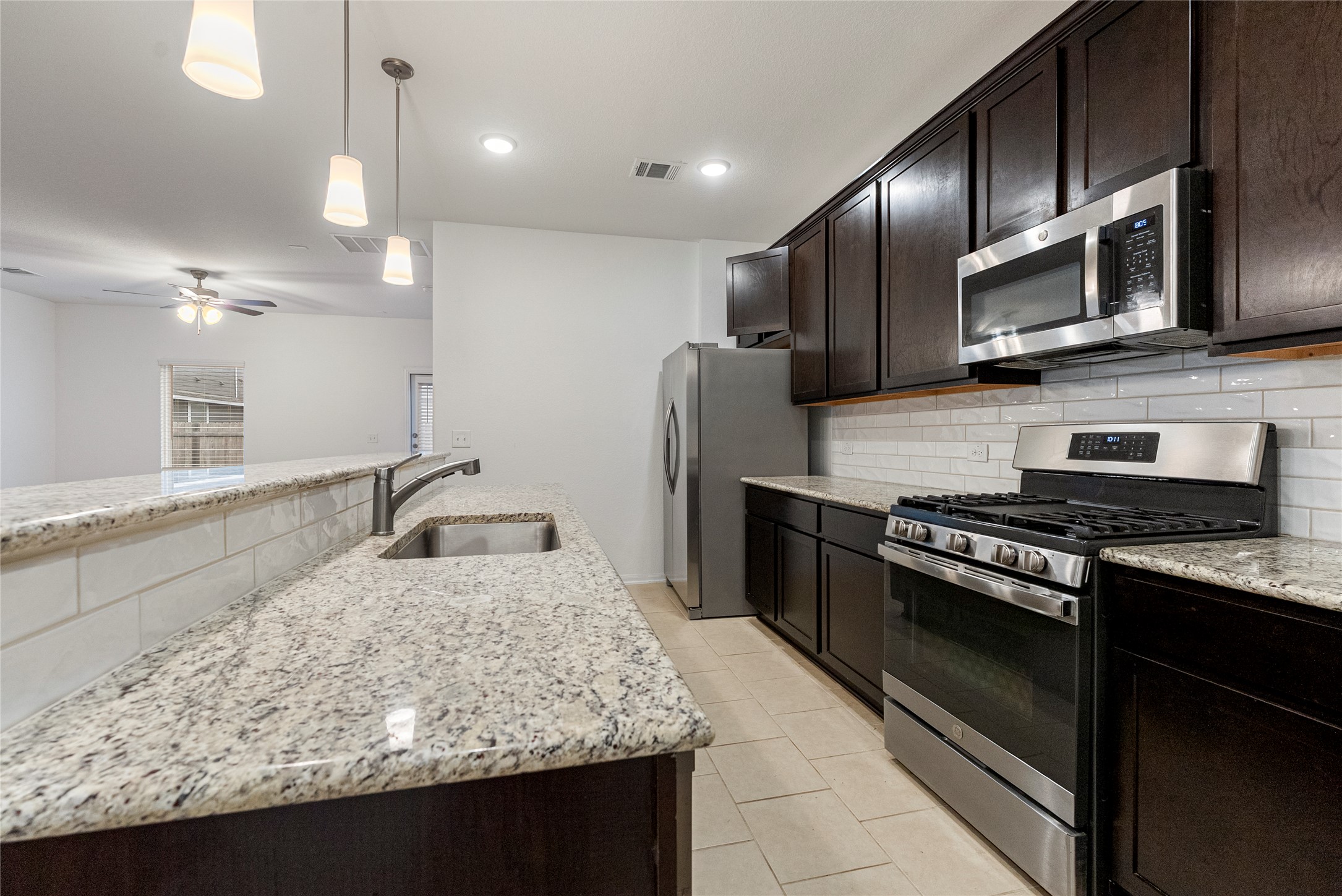 149 Biscayne Drive Kyle, TX 78640 - Photo 5 of 20 a kitchen with stainless steel appliances granite countertop a sink stove and refrigerator