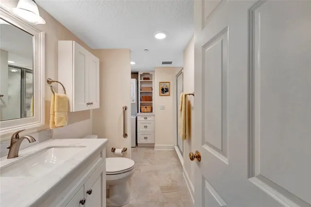 a bathroom with a granite countertop sink toilet and shower