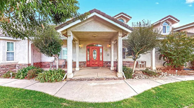 a living room with patio furniture and a potted plant