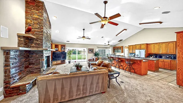 a living room with furniture a table and kitchen view