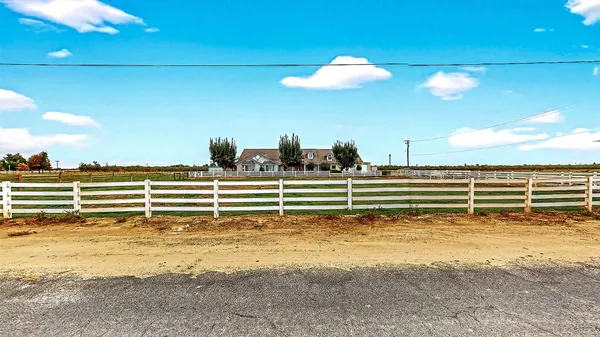 a view of a yard with wooden fence