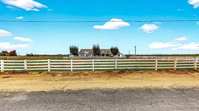 a view of a yard with wooden fence