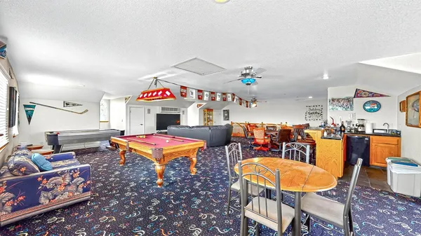 a view of a living room with stainless steel appliances wooden floor and a fireplace