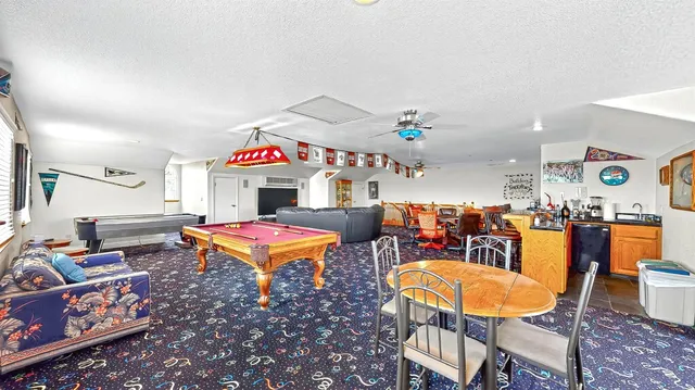 a view of a living room with stainless steel appliances wooden floor and a fireplace