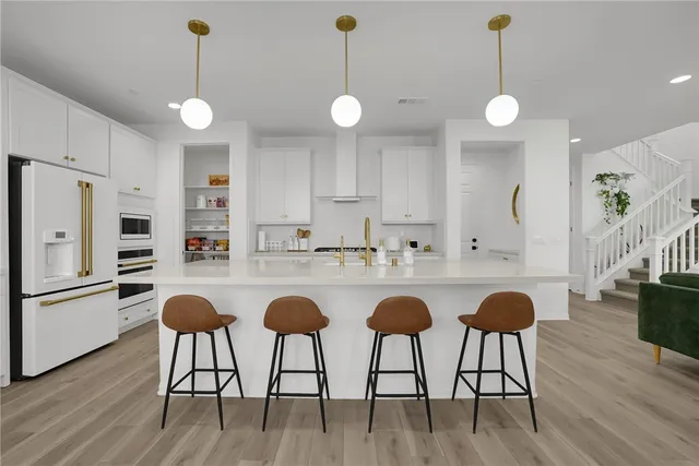 a kitchen with stainless steel appliances granite countertop a stove a sink island with wooden floor and cabinets