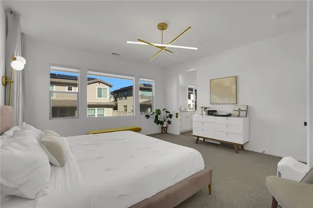 a bedroom with a large bed and a chandelier