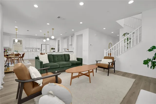 a living room with furniture and a dining table with wooden floor