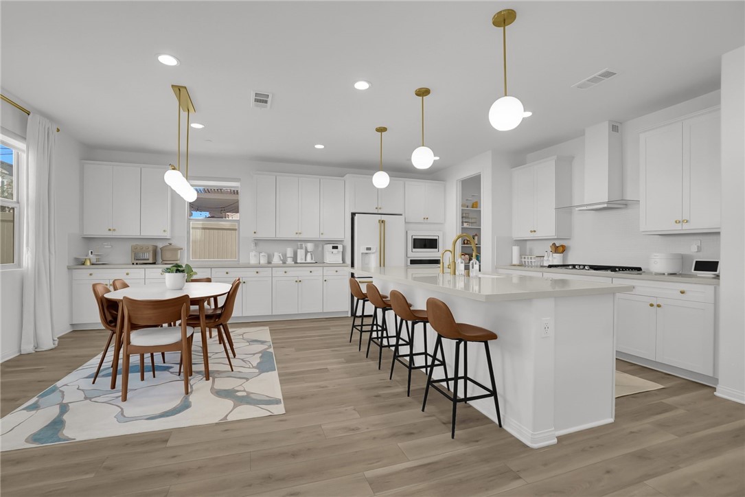 32136 Dymondia Way Temecula, CA 92591 - Photo 7 of 40 a kitchen with stainless steel appliances granite countertop a dining table chairs stove refrigerator and cabinets