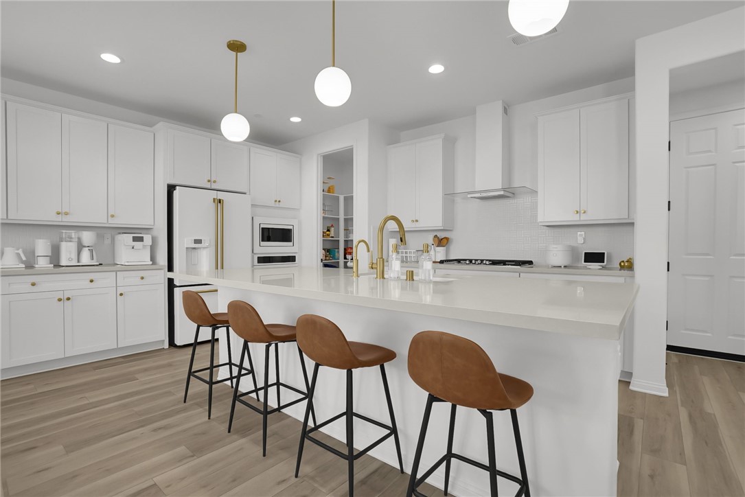 32136 Dymondia Way Temecula, CA 92591 - Photo 10 of 40 a kitchen with stainless steel appliances granite countertop a dining table chairs refrigerator sink and cabinets