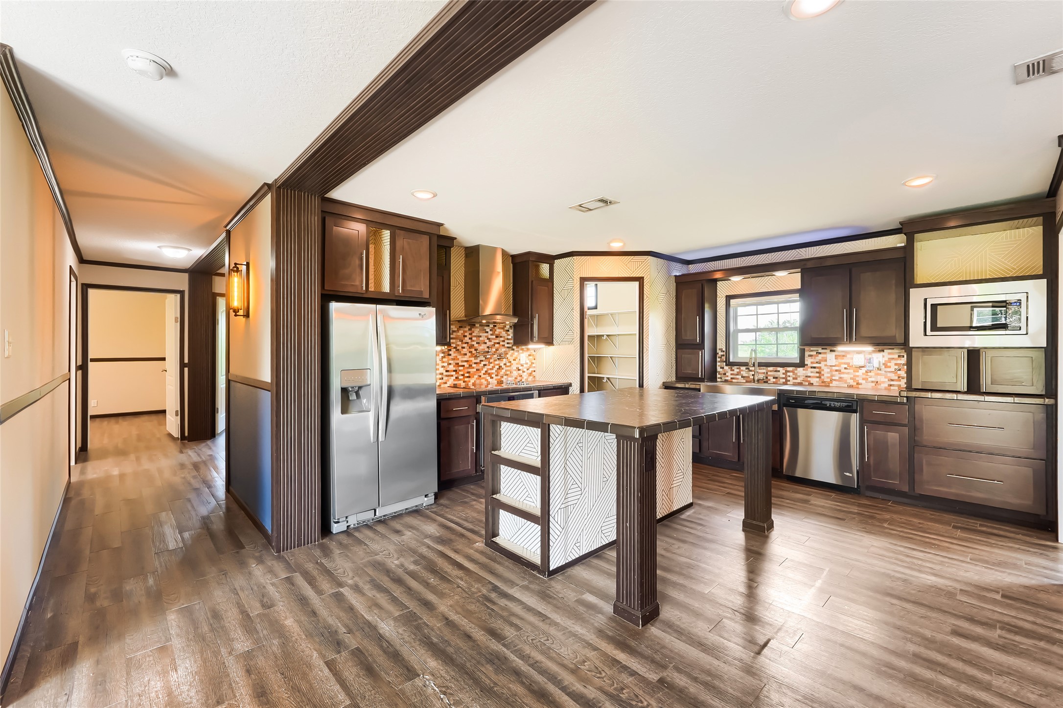 401 Graef Road Kyle, TX 78640 - Photo 12 of 30 An inviting kitchen with rich wood flooring and modern stainless steel appliances.