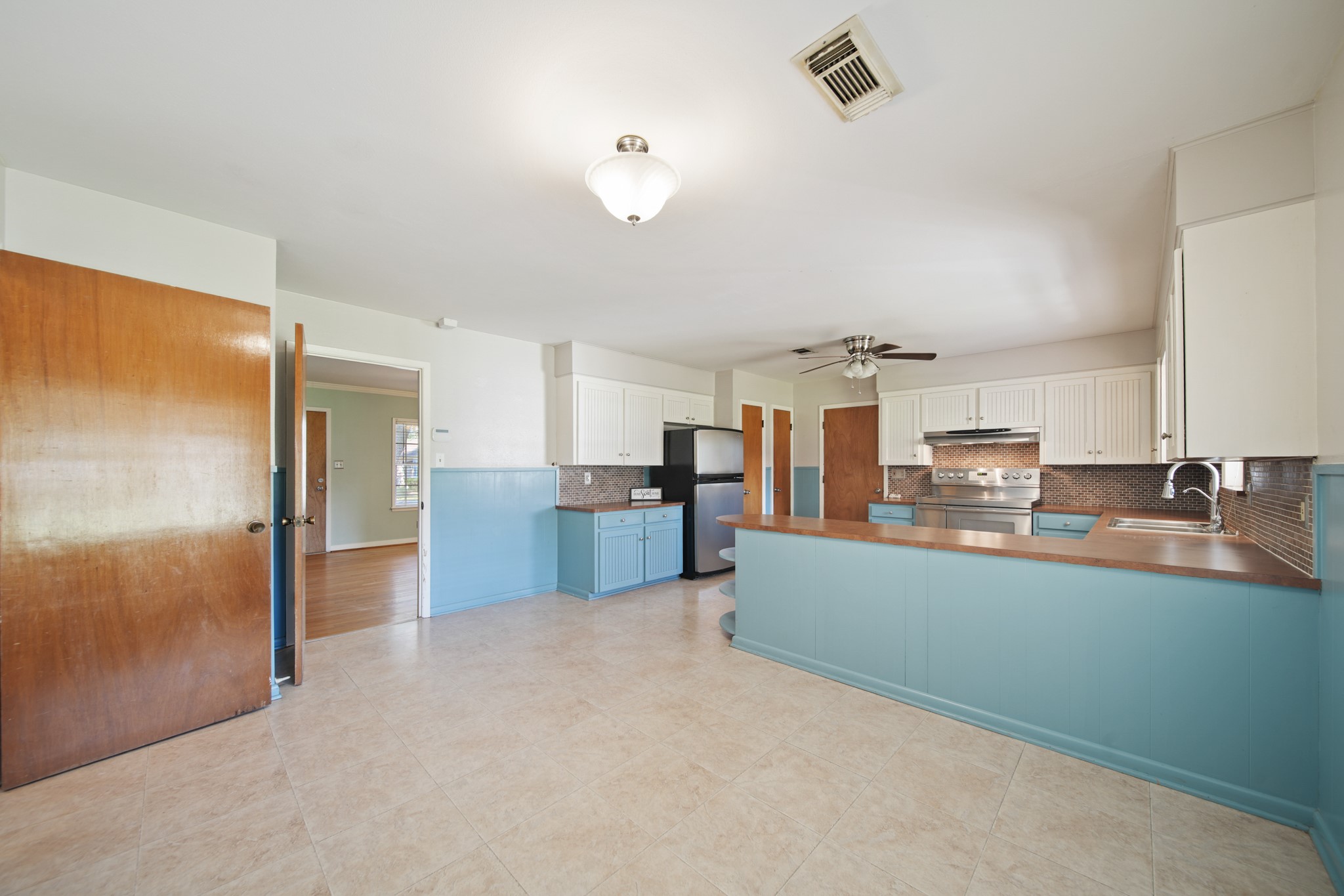 1811 Mulcahy Street Rosenberg, TX 77471 - Photo 11 of 25 a large kitchen with kitchen island a large counter top and stainless steel appliances