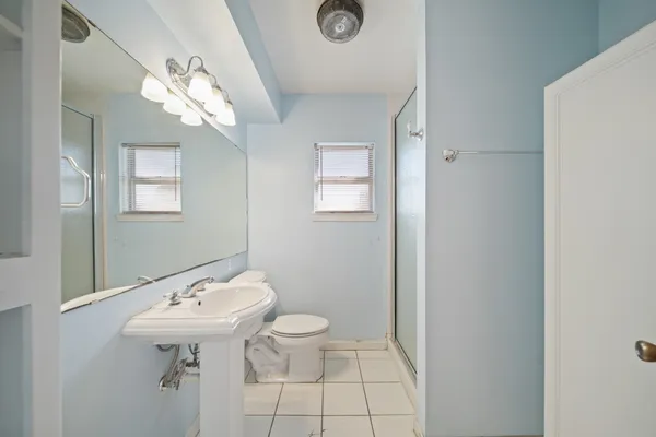 a bathroom with a sink a toilet and mirror