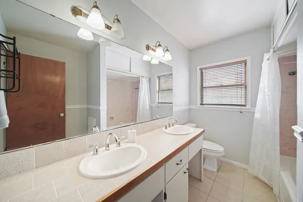 a bathroom with a granite countertop sink a toilet and a mirror