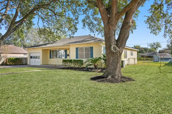 a front view of a house with a garden and trees