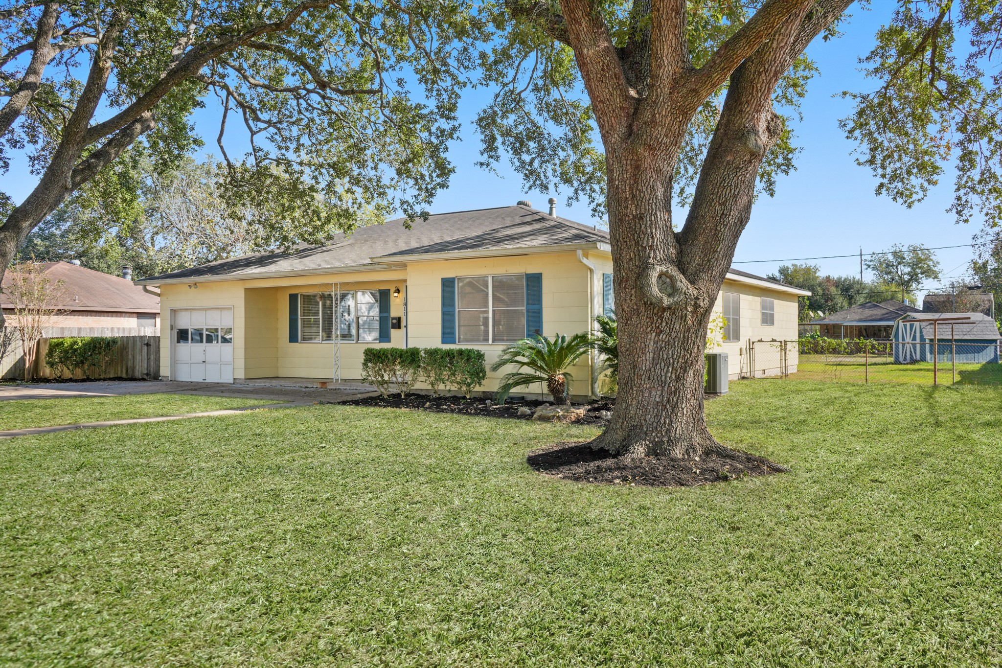 1811 Mulcahy Street Rosenberg, TX 77471 - Photo 2 of 25 a front view of a house with a garden and trees