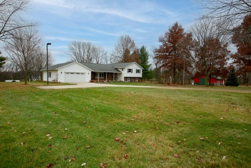 a view of a big house with a big yard and large trees