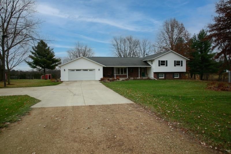 6727 North 5 Corners Road Lena, IL 61048 - Photo 16 of 20 a front view of a house with a yard and garage