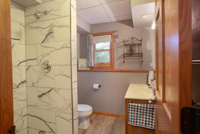 6727 North 5 Corners Road Lena, IL 61048 - Photo 7 of 20 a bathroom with a sink toilet and shower