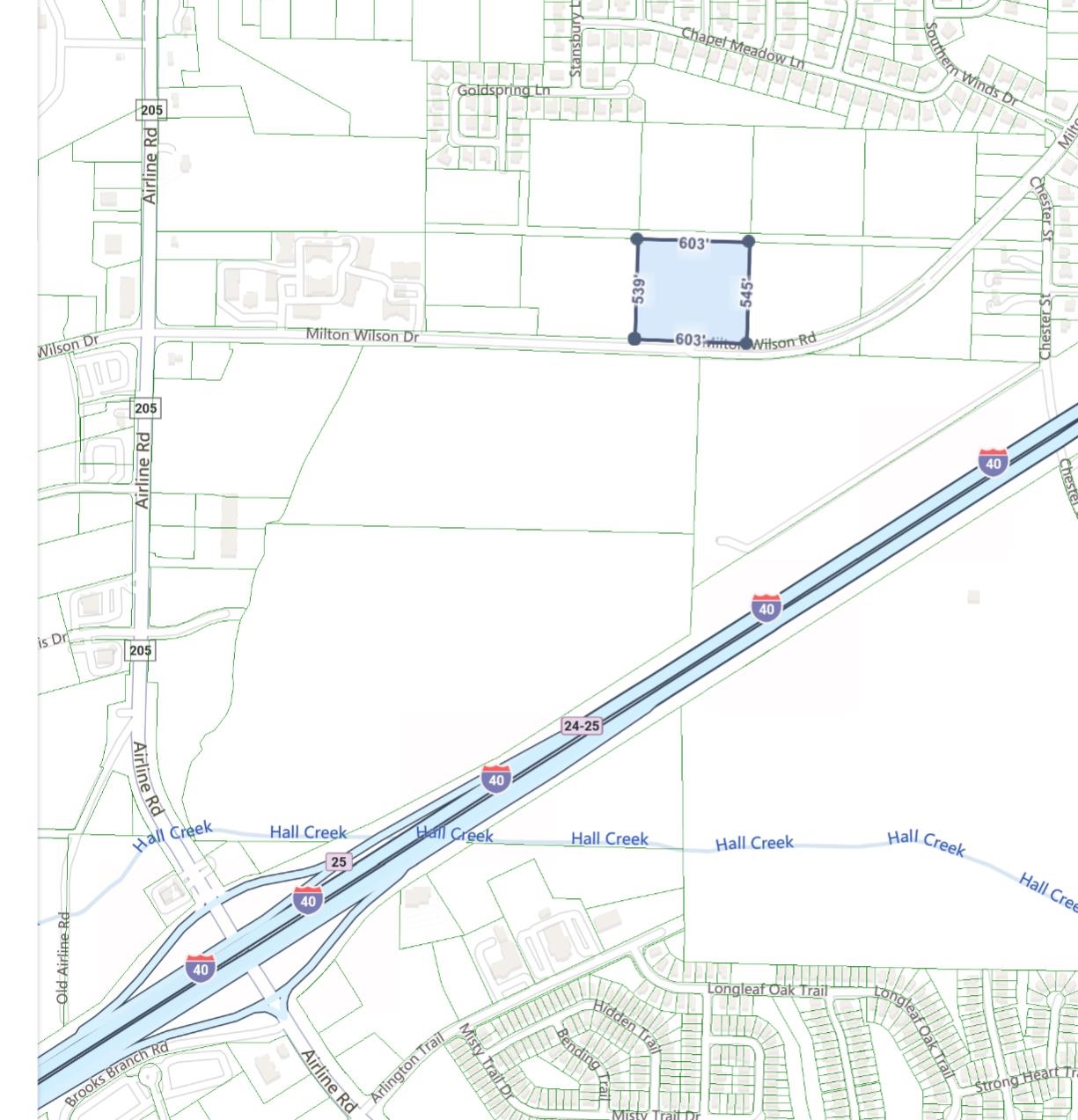 a view of a wooden floor with a white wall and a large window