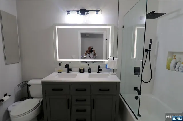 a bathroom with a sink vanity mirror and toilet