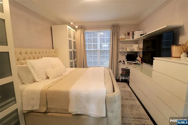 a bedroom with a large bed and a flat screen tv