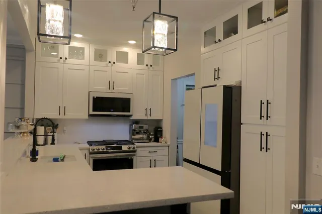a kitchen with stainless steel appliances a refrigerator sink and cabinets