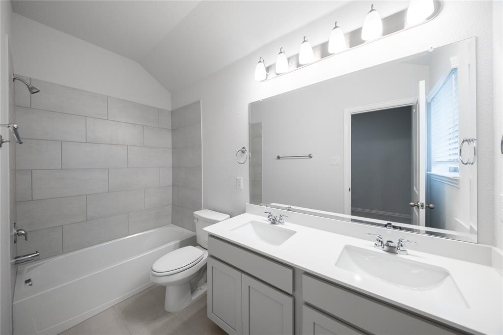 2606 Hawkins Street Anna, TX 75409 - Photo 2 of 31 a bathroom with a sink a toilet and shower