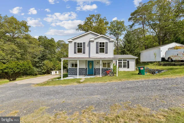 a view of a white house with a yard and sitting area