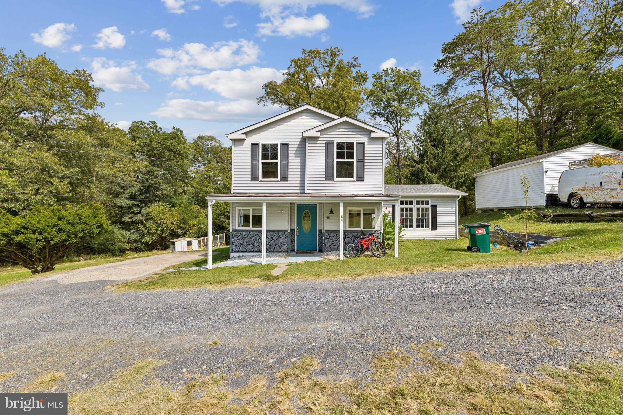 a view of a white house with a yard and sitting area