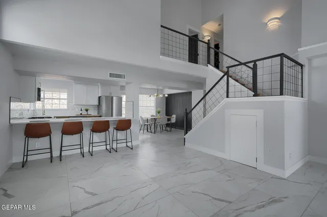 a kitchen with stainless steel appliances granite countertop a table chairs and a refrigerator