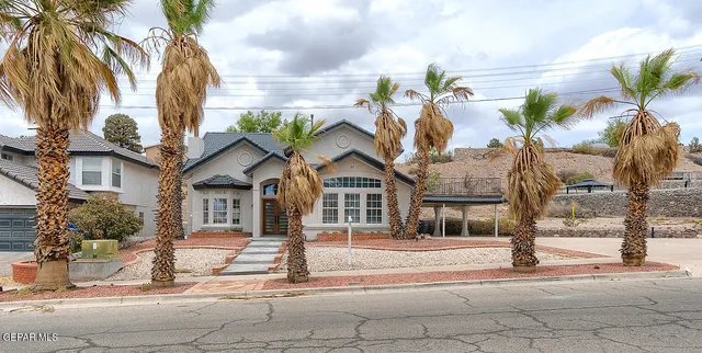 a front view of a house with a tree