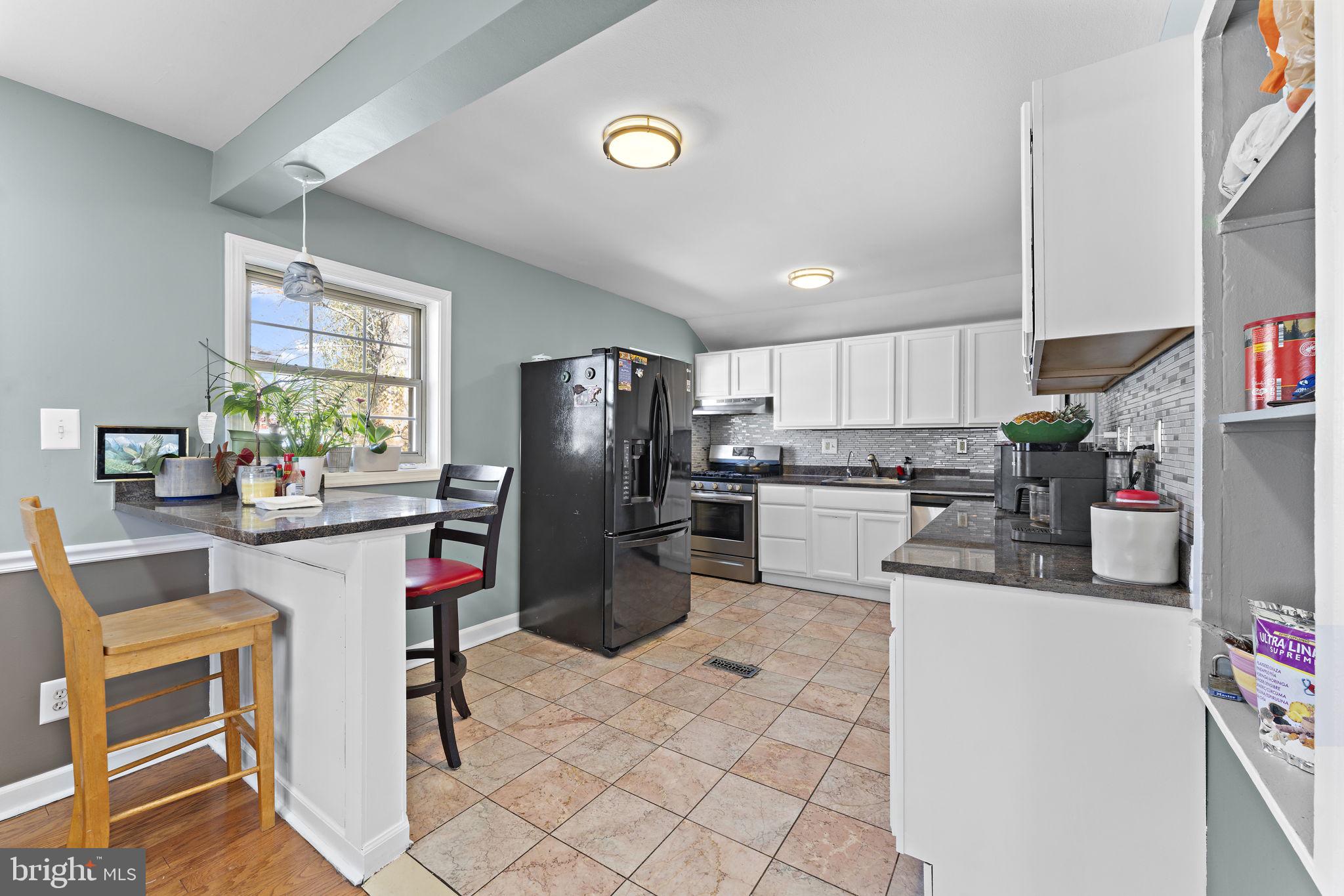 12911 Valleywood Drive Silver Spring, MD 20906 - Photo 7 of 43 a kitchen with refrigerator cabinets and wooden floor