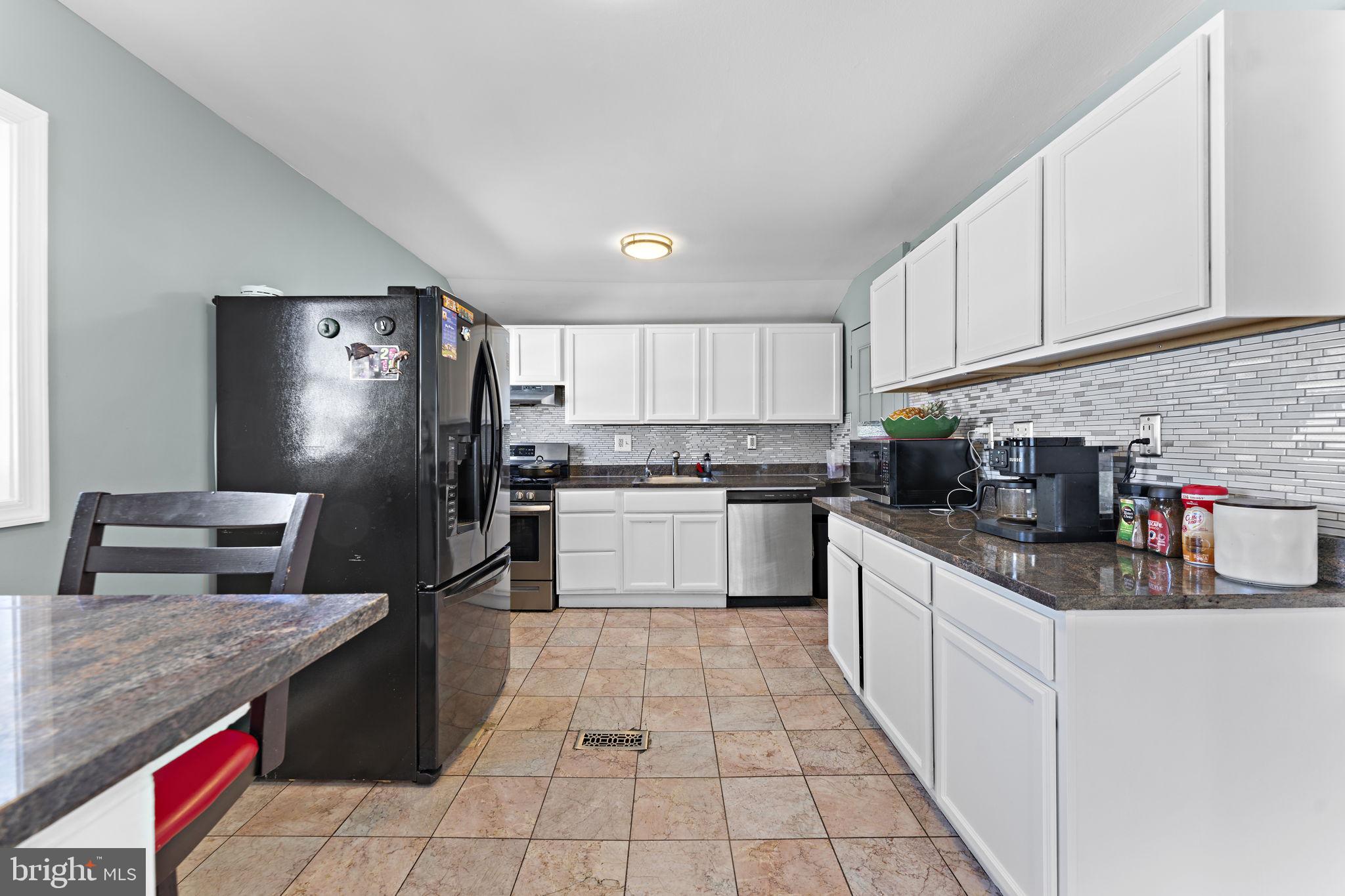 12911 Valleywood Drive Silver Spring, MD 20906 - Photo 9 of 43 a kitchen with stainless steel appliances granite countertop a sink dishwasher stove top oven and refrigerator