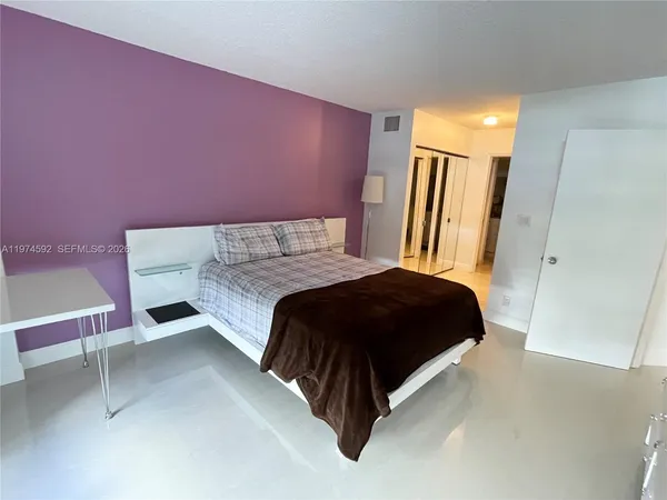 a bedroom with a bed and a mirror