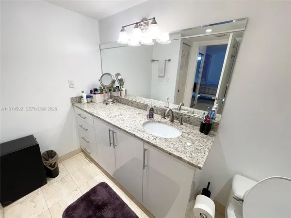 a bathroom with a sink vanity granite and a mirror