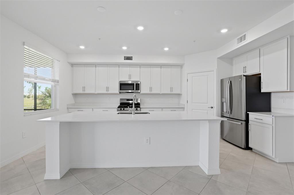 19219 Cherrystone Way, Unit 101 Lakewood Ranch, FL 34211 - Photo 4 of 19 a kitchen with stainless steel appliances granite countertop white cabinets a refrigerator and a stove