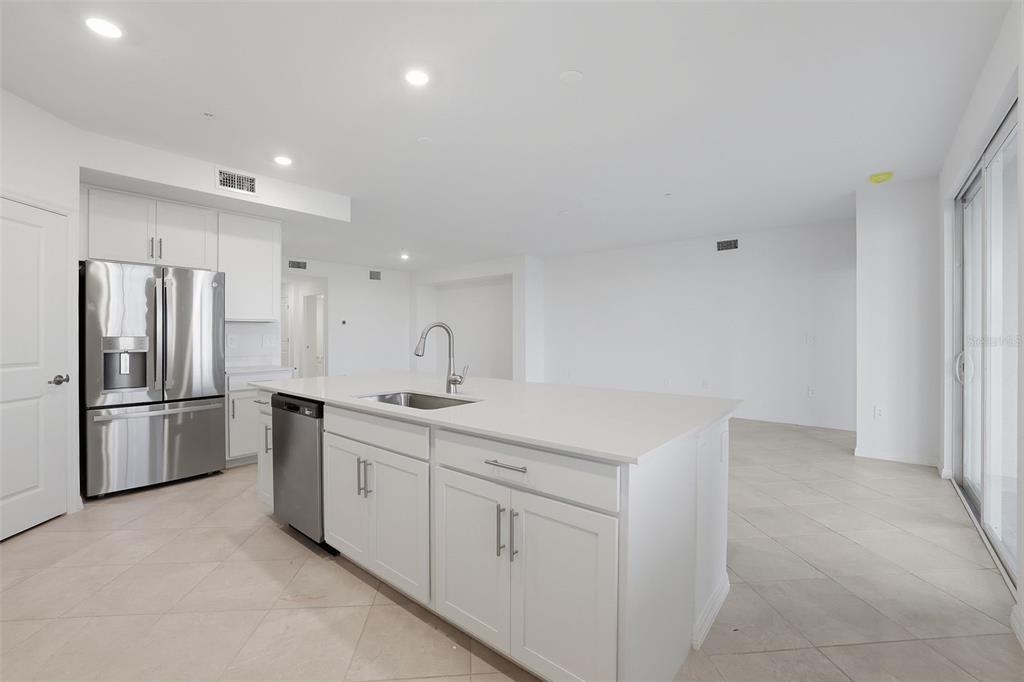19219 Cherrystone Way, Unit 101 Lakewood Ranch, FL 34211 - Photo 5 of 19 a kitchen with white cabinets and stainless steel appliances