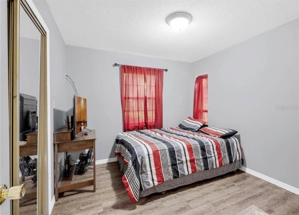 4308 Allen Road Fruitland Park, FL 34731 - Photo 25 of 33 a bedroom with a bed and dresser with wooden floor