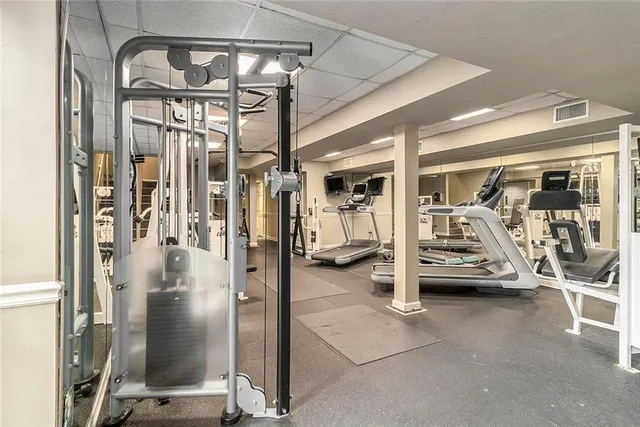 a view of a patio with couches table and chairs under an umbrella with palm trees