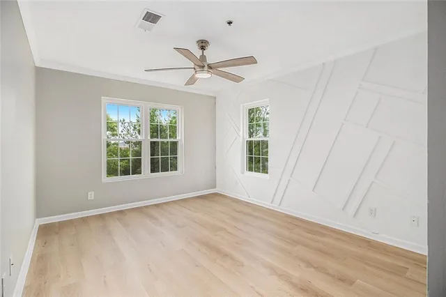 a view of an empty room with a window and wooden floor