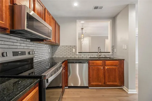 a kitchen with stainless steel appliances granite countertop a sink and cabinets