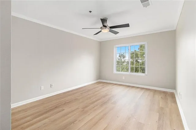 an empty room with a window and a fan