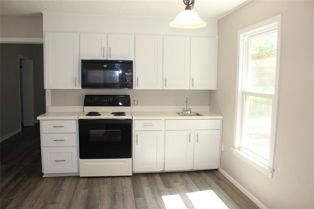 409 West Main Street Azle, TX 76020 - Photo 2 of 12 a kitchen with a stove microwave and a sink
