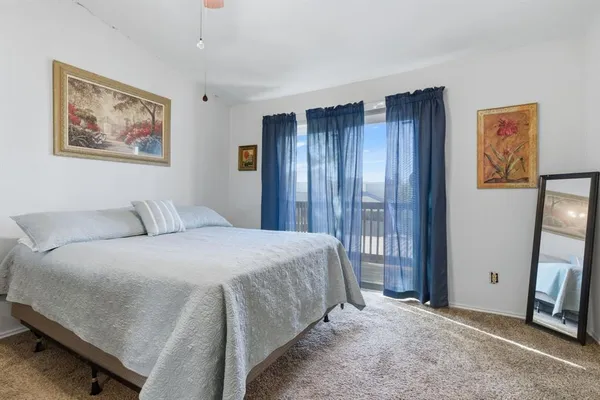 a spacious bedroom with a bed and a flat screen tv