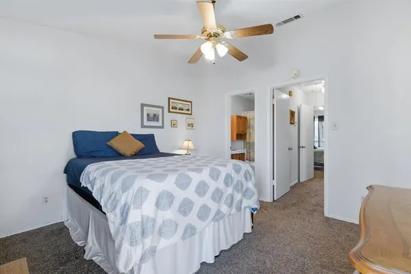 a bedroom with a bed and ceiling fan