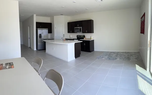 a large white kitchen with a sink a stove a microwave and a refrigerator