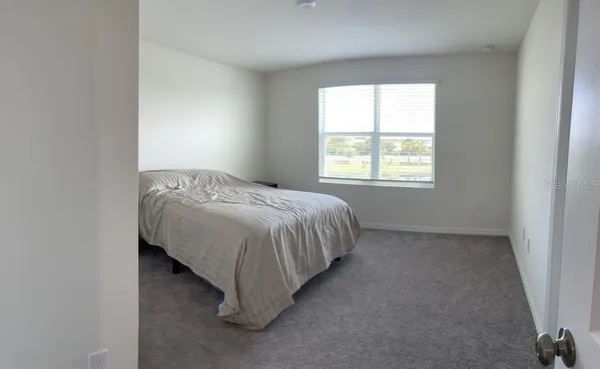 a bed sitting in a bedroom next to a window