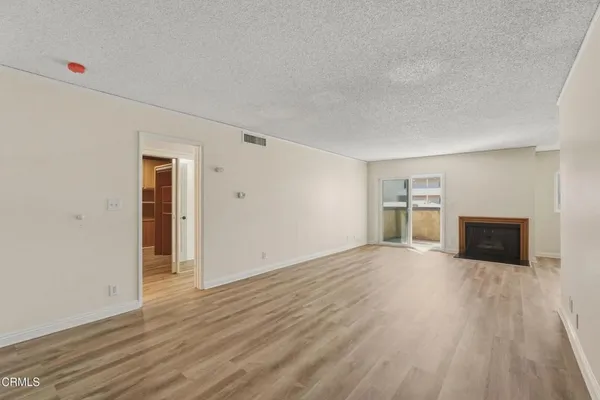a view of empty room with wooden floor and window