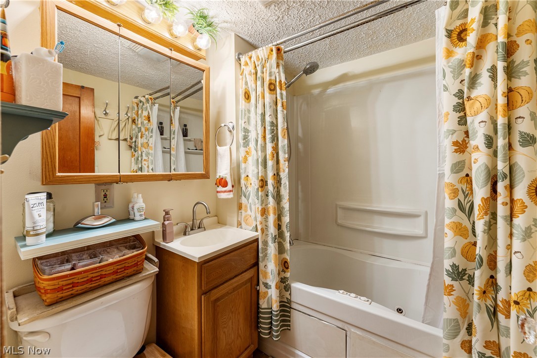 7000 Navarre Road Southwest Massillon, OH 44646 - Photo 20 of 22 The bathroom features a vanity with a sink, a mirrored medicine cabinet with overhead lighting, and a bathtub with a shower