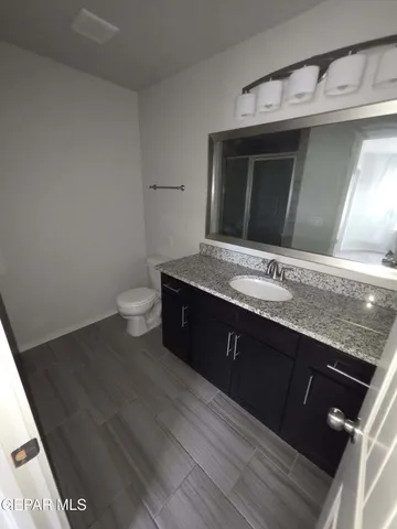 a spacious bathroom with a granite countertop sink and a mirror